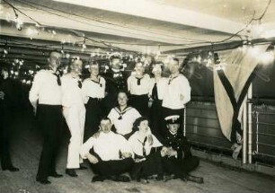 Gruppenbildnis mit maritim kostümierten Touristen an Deck eines Hochseepassagierdampfers ("Cleveland"?)