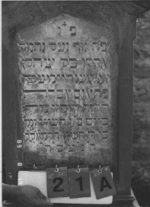 Grabstein 21 (Index: 100105742) Material: Sandstein und Marmor Zustand: stärker verwittert am Sockel Maße HxBxT: 158x64x31 cm Beschreibung: Stele, getreppter und profilierter Sockel, Giebel mit Akroteren, Schriftfeld eingetieft: Grabstein 21A