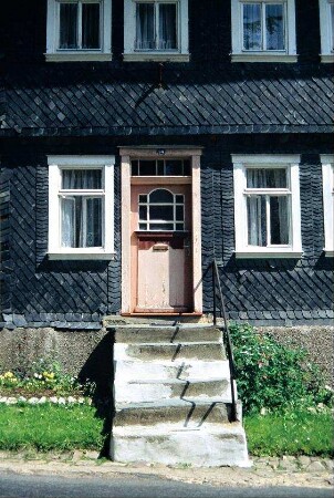 Eingangsbereich eines Hauses; Treppe mit Geländer und Haustür