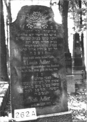 Grabstein 262 (Index: 99898600) Material: Granit? Zustand: gut erhalten Maße HxBxT: 107x45x20 cm Beschreibung: aufgesockelte Stele mit oben abgeflachtem Dreiecksabschluss: Grabstein 262A