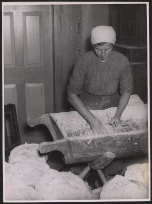 Eine Frau beim Kneten in der Brotteigwanne
