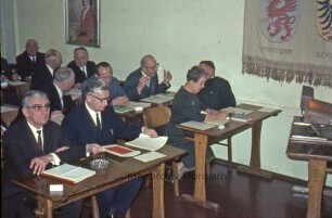 Kreistagssitzung: Kreisberufsschule [Bad Oldesloe]: Grabauer Straße / Ecke Lorentzenstraße: Aula: Kreistagsmitglieder an Schulbänken, darunter Gertrud Lege
