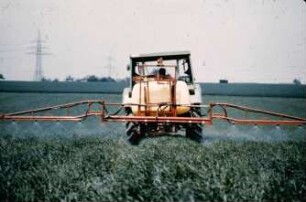 Fotografie: Traktor, Feldspritze angebaut, Getreide