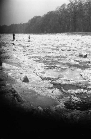 Eisschollen auf der Weißen Elster : Zwei Personen laufen über die Eisschollen der Weißen Elster