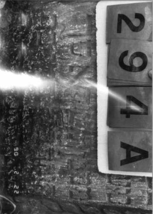 Grabstein 294 (Index: 100115889) Material: Sandstein Zustand: stark verwittert, zum Teil im Boden versunken Maße HxBxT: 92x66x11 cm Beschreibung: Stele mit konkav eingezogenem, überragendem Segmentbogenabschluß, eingetieftes Schriftfeld Symbolik: Levitenkanne, Ranken: Grabstein 294A (Detailaufnahme 2)