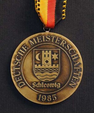 Bronzemedaille Deutsche Meisterschaften in Kurzschrift und Maschinenschreiben in Schleswig 1985 am schwarz-rot-goldenen Band : Sammlung Deutscher Stenografenbund. Bronzemedaille Deutsche Meisterschaften in Kurzschrift und Maschinenschreiben in Schleswig 1985 am schwarz-rot-goldenen Band. Messing, patiniert; Durchmesser 50 mm, Gewicht 48 g (1985; Deschler & Sohn, München). Dresden: SLUB R c 0541