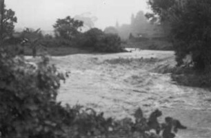 Angeschwollener Fluss : Nach Starkregen ist ein Fluss zu einem Strom angeschwollen und über die Ufer getreten.