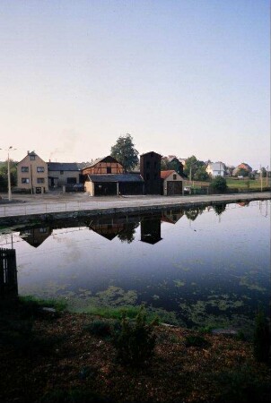 Teich und Gebäude, unter anderem Schlauchturm