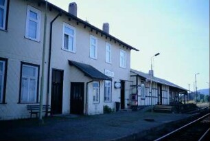 Rückseite des Bahnhofgebäudes mit alter Uhr und Güterschuppen