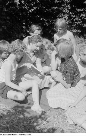 Büchereiangestellte Krüger der Stadtbücherei Mitte liest Kindern aus einem Buch vor