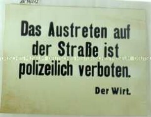 Schild "Das Austreten auf der Straße ist polizeilich verboten"
