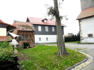 Eicha-Evangelische Kirche - Kirchhof im Nordosten mit angerenzenden Gebäuden (die Grenze des ehemaliegn Kirchhofes bezeichnend)