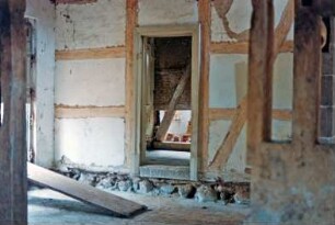 Nütschau: Schloßstraße 43: ehemalige Kornwassermühle: mit Reetdach: Restaurierung: Innenansicht: Innenwand, Gefache mit Vermauerung, Wandfundamente, Wandschwellen, Türdurchgang