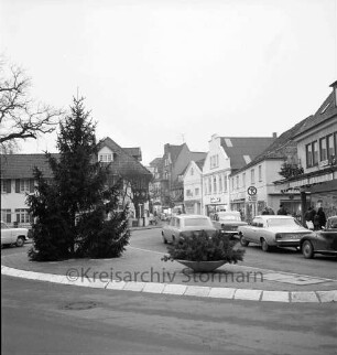 Besttorstraße Ecke Bahnhofstraße: Tannenbaum ohne eingeschaltete Adventsbeleuchtung auf der Verkehrsinsel, rechts die Besttorbrücke mit parkenden Pkws und Gebäuden ohne eingeschaltete Adventsbelechtung, Blick Richtung Norden
