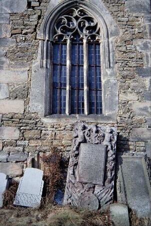 gotisches Fenster mit Maßwerk in der Kirche, Grabsteine an der Außenwand