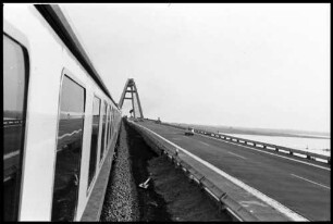 Fehmarnsund: Fehmarnsundbrücke, aus Seitenfenster mit Zug und Straße