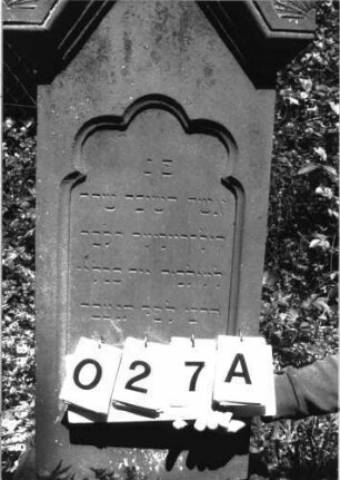 Grabstein 27 (Index: 100101186) Material: Sandstein Zustand: am Sockel verwittert Maße HxBxT: 133x49x26 cm Beschreibung: Stele, profilierter Sockel, eingezogener giebelartiger Abschluß rechteckig erhöht mit Verdachgung und Eckakroteren, Schriftfeld mit Rundbogenabschluß Symbolik: Rundbogenfries um das Schriftfeld, Blätter in den Akroteren: Grabstein 27A