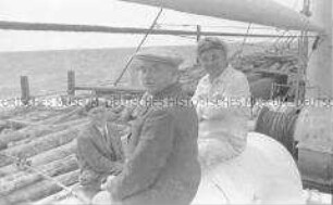 Selbstversenkung des Hochseepassagierdampfers "Columbus" am 19. Dezember 1939, Heimfahrt der älteren Besatzungsangehörigen (54-60 Jahre) vom Internierungslager auf Angel Island, Kalifornien, auf dem italienischen Dampfer "Fella", drei Männer auf dem mit Holzstämmen voll beladenen Vorderdeck sitzend