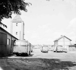 früherer Bahnhof der Südstormarnschen Kreisbahn: parkende Busse, rechts das frühere Bahnhofsgebäude
