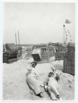 Am Strand - Mann und Frau im Sand liegend