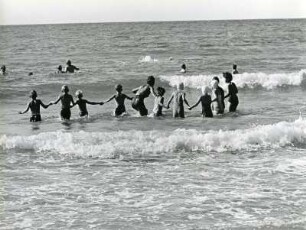 Hörnum Sylt. Kinderheim der Arbeiterwohlfahrt (AWO). Kinder und Jugendliche spielen und toben in der Brandung der Nordsee