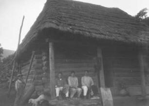 Haus in Ayutla : Drei Männer sitzen vor einem Holzhaus