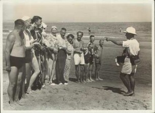 Fotograf lässt Badegäste am Strand posieren
