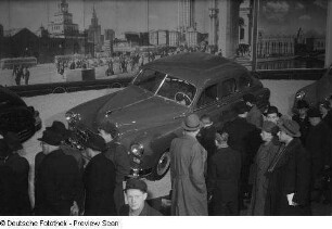 Besucher vor einem sowjetischen Automobil des Typs GAZ-M20 Pobeda