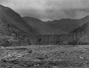 Flussbett : Ein Flussbett in einem Tal im Tian Shan Hochgebirge. Im Hintergrund eine mauerartige Felsformation