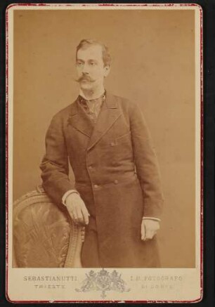 Hugo von Hofmannsthal senior stehend, den Arm auf einen Sessel lehnend