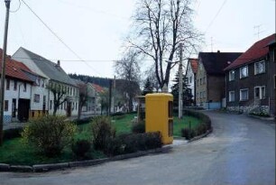 Straßenzug mit Grünfläche in der Mitte, Telefonzelle