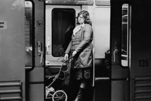 Frau mit Kinderwagen in der U-Bahn