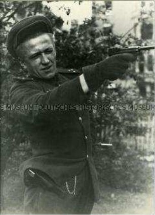 Sowjetischer Soldat posiert mit gezogener Pistole