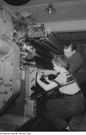 Meister mit Lehrling an einer Druckmaschine