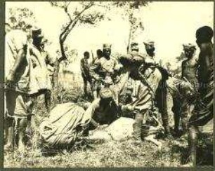 Afrikanische Träger und Askaris beim Ausweiden eines erlegten Tieres
