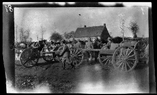 [Bei Langenmark (=Langemark, Belgien), Roulers (=Roeselare, Belgien) oder Bailleul Bei Arras (=Bailleul-Sir-Berthoult, Dep. Pas-de-Calais, Frankreich)]: "Geschütze der Feldartillerie" auf einem Platz am Ortsrand, im Hintergrund ein Wohngebäude