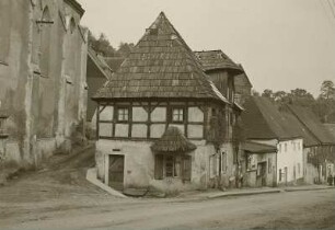 Graupen (heute Krupka / Tschechien). Hauptstraße. Straßenbild mit Fachwerkhaus (neben der Pfarrkirche)