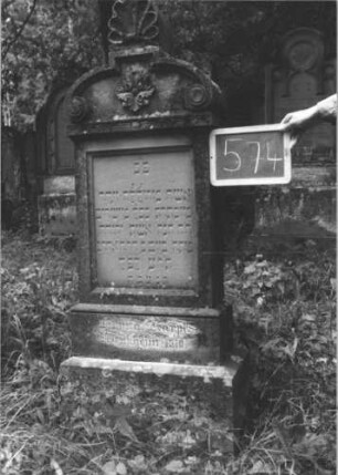 Grabstein 574 (Index: 99895390) Material: Sandstein Zustand: gut Maße HxBxT: 153x50x20 cm Beschreibung: Stele mit Volutenabschluss und Mittelakroter; Sockel Symbolik: Blüte: Grabstein 574 (1)