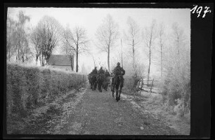 Wallonische Region (Belgien): Kavallerie von hinten beim Ritt aus einer nicht identifzierbaren Ortschaft ("Auf dem Marsch in Belgien")