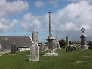 Klosterfriedhof : Friedhof mit jahrhundertealten Grabsteinen, links Teil des Klostergebäudes und dahinter Wehrturm des Klosters von Clonmacnoise, 545 gegründet. Aufgenommen im April 2005. Foto Uwe Gerig