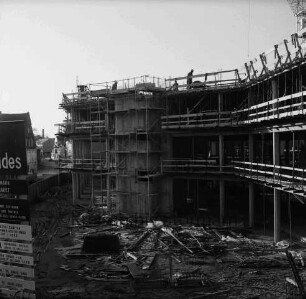 Kreissparkasse Stormarn: Hagenstraße: im Bau mit Bauzaun und Gerüst: Blick von Rathaus auf Baustelle mit Baumaterial und Arbeitern: vorn links Bauschild: dahinter Wohn- und Geschäftshäuser: 19. Dezember 1975