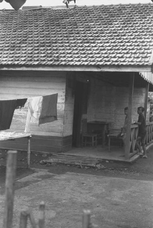 Haus einer javanischen Arbeiterfamilie : Blick auf ein Holzhaus mit Bewohnern