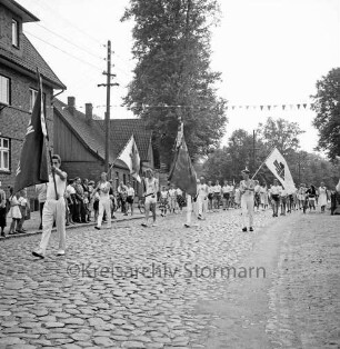 Turn- und Sportverein TSV Bargteheide von 1868: 90-jähriges Jubiläum und Kreisturnfest: Umzug: vorne Turner mit Vereinsfahnen und Fahne des Deutschen Turner-Bundes: dahinter Turnerinnen und Turner: Zuschauer am Straßenrand, 7. September 1958
