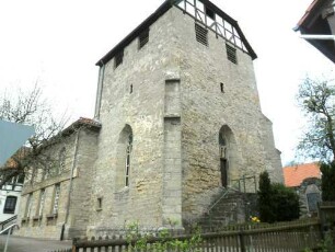 Evangelische Kirche - Kirchturm (gotischer Chorturm) von Südosten mit Schießscharten (Schlitzscharten) sowie Strebepfeilern und Krüppelwalmdach (Fachwerk im Osten)