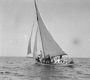 Blick auf ein Segelboot mit Passagieren in geringer Entfernung auf offener See