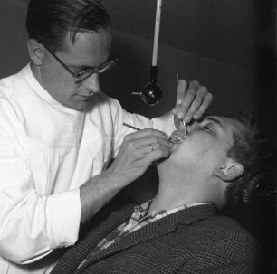 Braun Gesundheitsdienst. Zahnarztpraxis. Zahnarzt bei der Behandlung eines männlichen Patienten