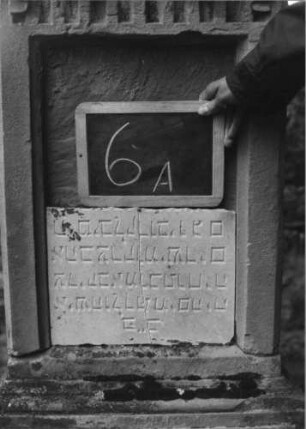 Grabstein 6 (Index: 100080725) Material: Sandstein, weiße Marmorplatte Zustand: Platte gesprungen, Aufsatz beschädigt Maße HxBxT: 165x49x27 cm Beschreibung: Stele, getreppter Sockel, Giebel mit Aufsatz, rechteckige Schriftplatte: Grabstein 6A