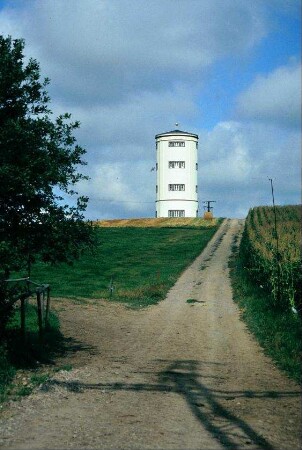 Blick entlang eines Feldweges auf Wasserturm