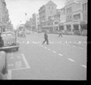 Mann beim Überqueren einer belebten Geschäftsstraße, Durban, Südafrika