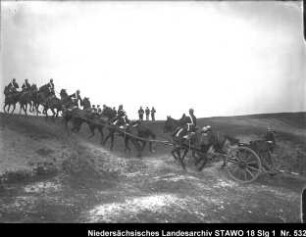 Geländeübung und Besichtigung des Feld-Artillerie-Regiments Nr. 46 Enthält: Soldaten auf mit Pferden bespannter Geschützlafette reiten eine Anhöhe hinauf